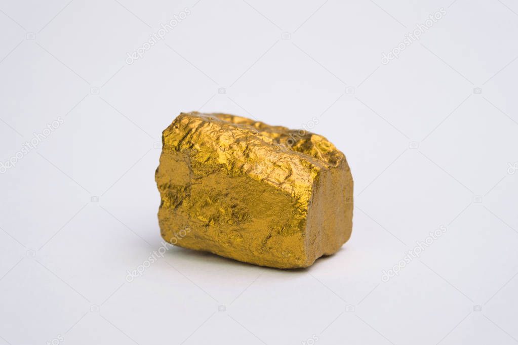 Closeup of gold nugget or gold ore isolated on white background, precious stone or lump of golden stone, financial and business concept idea.
