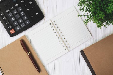 Dolma kalem veya tükenmez kalem defter kağıt ve ahşap çalışma masa kopya alanı, office Danışma konsept fikir ile hesap makinesi ile. Üstten Görünüm.