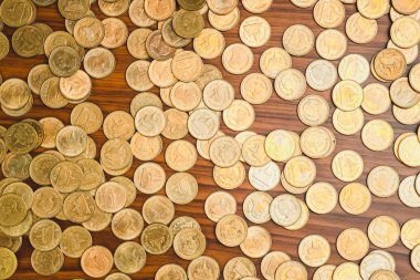 Ahşap çalışma masa, iş ve finans kavramı fikri üzerine sikke yığını.