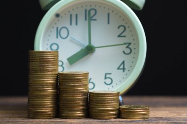 Çalar saat ve karanlık bir odada, tasarruf para kavramı, bankacılık ve iş kavramı fikri çalışma tablo para yığınları.