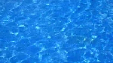 Ağır çekim mavi ve parlak dalgalanma temiz su yüzeyi güneş yansıması, tam Hd ile yüzme havuzunda.