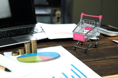 Çalışma tablosu, iş görme ve Finans analiz kavramı fikir planlaması üzerinde kağıt üzerinde adım para yığınları arabası ve dizüstü dizüstü bilgisayar ve mali grafik ile /. ve kopya alanı için metin ekleme.