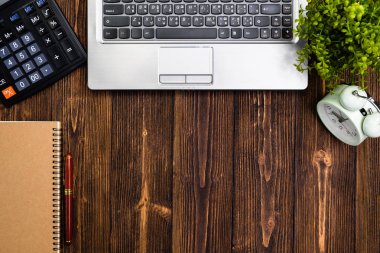 Ofis, banka donatımı veya office çalışma temel araçları veya öğeleri çalışma alanı, dizüstü bilgisayar dizüstü bilgisayar hesap makinası ve çalar saat ahşap masa üzerinde en iyi görünüm için kopya alanı ile eklemek metin ve mesaj.