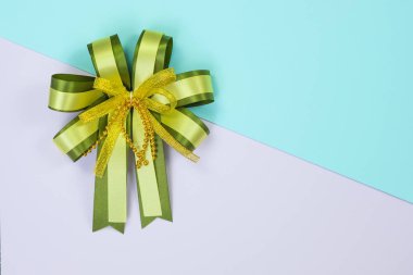 Dekoratif yeşil şerit yay tatlı pastel renkli kağıt arka plan doku, kopya alanı için ile yukarıdan görünüm eklemek metin, Festivali veya promosyon ve özel gün kavram fikir için şablon.
