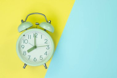 Tatlı pastel renkli kağıda üstten görünüm, arka plan dokusu, pembe, mor, sarı, bej, yeşil ve mavi renkli düz yatıyordu vintage çalar saat.