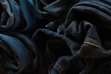 Frayed kot pantolon ya da kot denim koleksiyonu kaba ahşap masa arka plan kopya alanı, eski moda stil kavramı ile rulo.