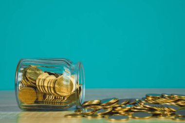 Madeni para yığınları ve altın sikke para cam kavanoz tablo kaydetme gelecekteki bankacılık finans için yeşil arka plana sahip konsept fikir.