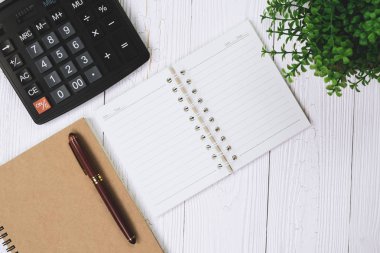 Dolma kalem veya tükenmez kalem defter kağıt ve ahşap çalışma masa kopya alanı, office Danışma konsept fikir ile hesap makinesi ile. Üstten Görünüm.