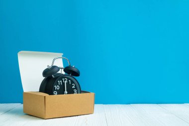 Kahverengi teslim karton kutu veya beyaz tahta ve mavi duvar arka plan, zaman ve son tarih kavramı fikir tepsiye Retro çalar saat.