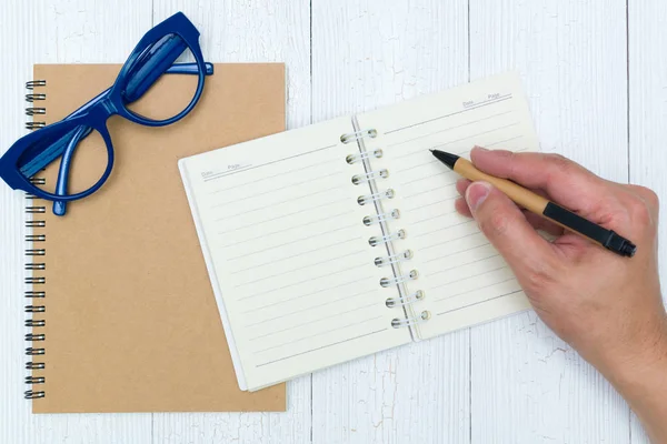 Adam el yazma, ahşap, gözlük ve ofis malzemeleri, üstten görünüm üzerinde kalem ile defter kağıt boş sayfa.