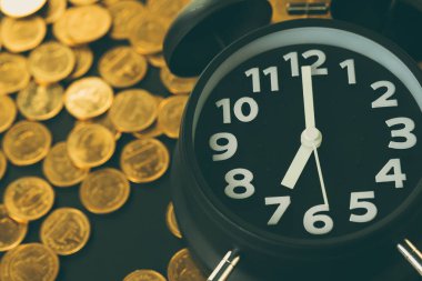 Çalar saat ve çalışma tablosu, tasarruf para kavramı, bankacılık ve iş kavramı fikri üzerinde para yığınları.