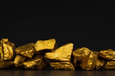 Altın nuggets veya siyah arka plan, kıymetli taş veya yumru altın taş, mali ve iş kavramı fikri altın cevheri yığını.