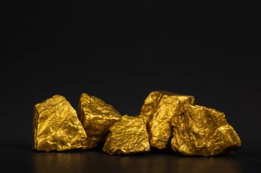 Altın nuggets veya siyah arka plan, kıymetli taş veya yumru altın taş, mali ve iş kavramı fikri altın cevheri yığını.