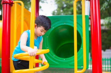 Etkin Asya metal spiral okul bahçesinde Bahçesi, tırmanma oynayan çocuk. Çocuklar oynamak ve açık havada günbatımı altında tırmanmaya.