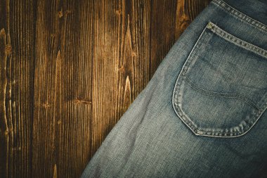 Kaba koyu ahşap masa arka plan, kopya alanı, eski moda stil kavramı ile üstten görünüm üzerinde yıpranmış kot pantolon ya da kot denim koleksiyonu.