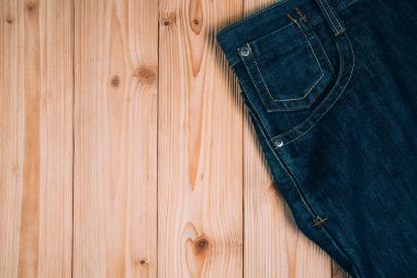 Kot pantolon ya da kot denim koleksiyonu kopya alanı, eski moda stil kavramı ile kaba ahşap masa arka plan üzerinde yıpranmış.