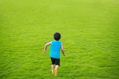 İleri büyük yeşil çim alanında çalışan küçük çocuk çocuk yaz günü. çocuk Özgürlük kavramı.