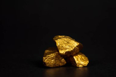 Altın nuggets veya siyah arka plan, kıymetli taş veya yumru altın taş, mali ve iş kavramı fikri altın cevheri yığını.