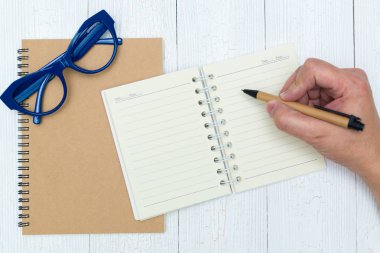 Adam el yazma, ahşap, gözlük ve ofis malzemeleri, üstten görünüm üzerinde kalem ile defter kağıt boş sayfa.