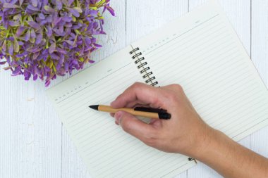 Adam el yazma, ahşap, büro malzemeleri, üstten görünüm üzerinde kalem ile defter kağıt boş sayfa.