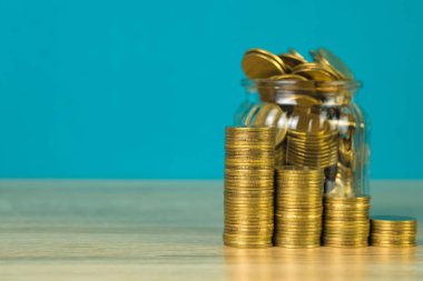 Madeni para yığınları ve altın sikke para cam kavanoz tablo kaydetme gelecekteki bankacılık finans için yeşil arka plana sahip konsept fikir.
