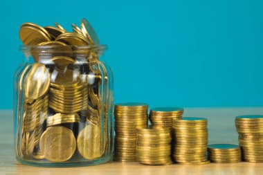 Madeni para yığınları ve altın sikke para cam kavanoz tablo kaydetme gelecekteki bankacılık finans için yeşil arka plana sahip konsept fikir.