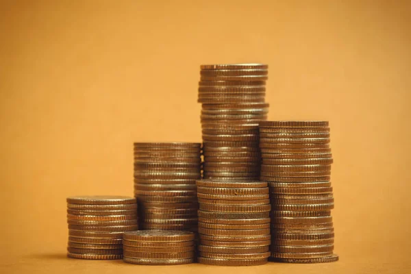 Columns of coins, piles of coins on brown background, business and financial concept idea.