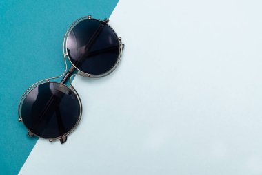 Üstten Görünüm düz yatıyordu, pastel kağıt arka plan dokusu üzerinde modern güneş gözlüğü.