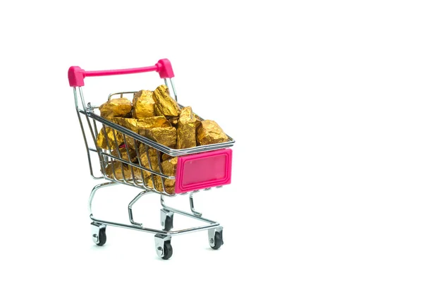Pile of gold nuggets or gold ore in shopping cart or supermarket trolley on white  background, precious stone or lump of golden stone, financial and business concept idea.