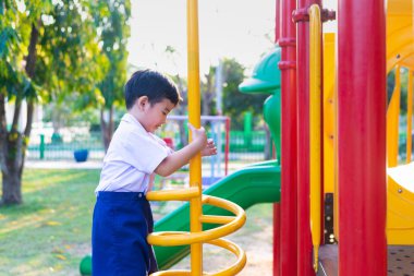 Etkin Asya metal spiral okul bahçesinde Bahçesi, tırmanma oynayan çocuk. Çocuklar oynamak ve açık havada günbatımı altında tırmanmaya.
