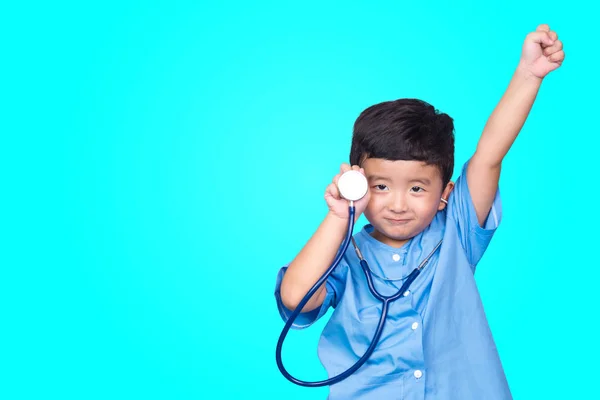 Smiling Asian kid in blue medical uniform holding stethoscope lo — Stock Photo, Image