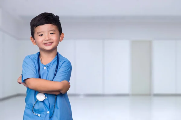 Sorridente asiatico bambino in blu medico uniforme holding stetoscopio lo — Foto Stock