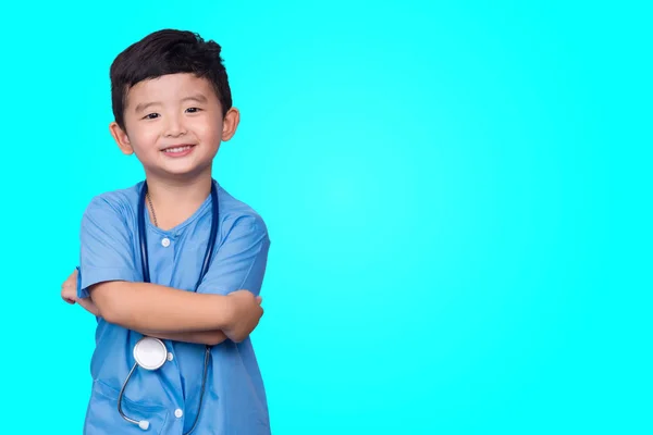 Sonriente niño asiático en uniforme médico azul celebración estetoscopio lo —  Fotos de Stock