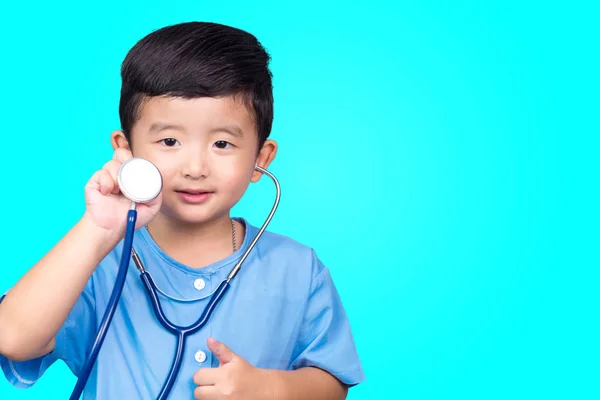 Sorridente asiatico bambino in blu medico uniforme holding stetoscopio lo — Foto Stock