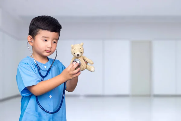 Sonriente niño asiático en uniforme médico azul celebración estetoscopio lo —  Fotos de Stock