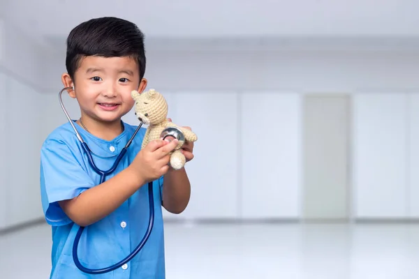 Smiling Asian kid in blue medical uniform holding stethoscope lo — Stock Photo, Image