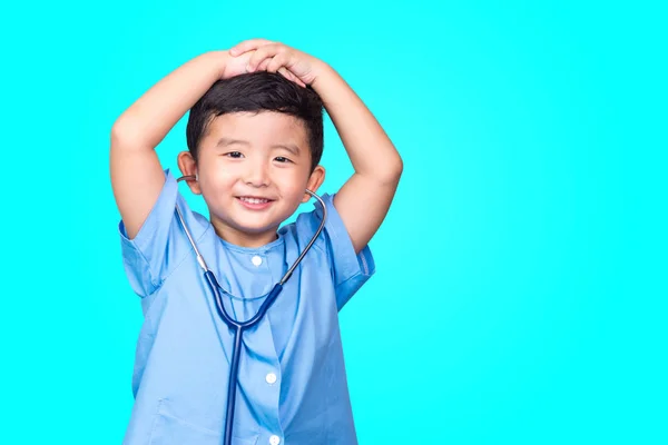 Sorrindo asiático criança em azul médico uniforme segurando estetoscópio lo — Fotografia de Stock