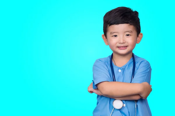 Sorridente asiatico bambino in blu medico uniforme holding stetoscopio lo — Foto Stock