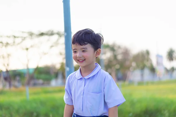 Outdoor portrait of a happy Asian student kid in school uniform — Stock Photo, Image