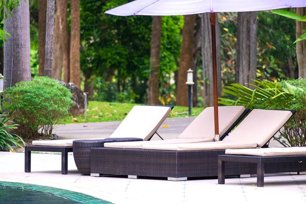 Ligstoel of zonnen in de buurt van prive-zwembad met zon umbrel — Stockfoto