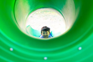 Küçük Asyalı Çocuk Bahçesi t altında adlı slayt yukarı tırmanma