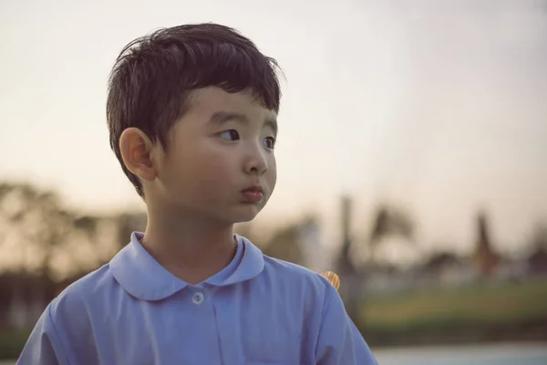 Retrato al aire libre de un niño estudiante asiático feliz en uniforme escolar — Foto de Stock