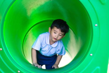 Küçük Asyalı Çocuk Bahçesi t altında adlı slayt yukarı tırmanma