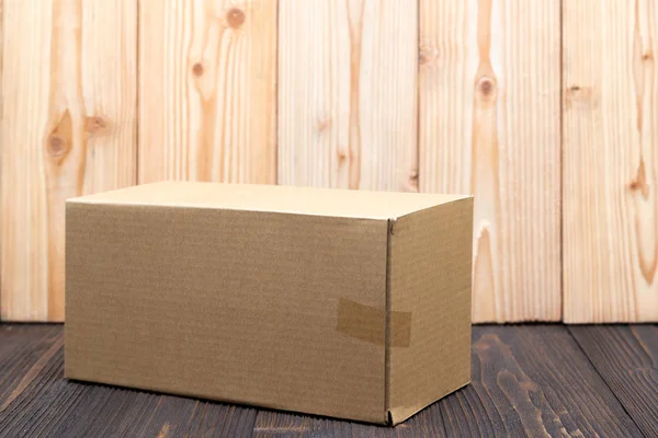 Pacote vazio caixa de papelão marrom ou bandeja em fundo de madeira , — Fotografia de Stock