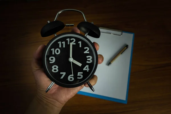 Relógio de alarme vintage preto na mão com área de transferência e branco em branco — Fotografia de Stock