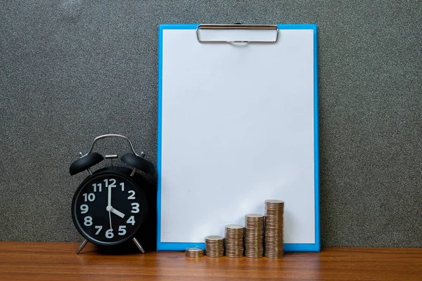 Alarm clock and step of coins stacks with clipboard and white pa — Stock Photo, Image