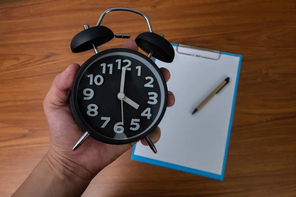 Relógio de alarme vintage preto na mão com área de transferência e branco em branco — Fotografia de Stock