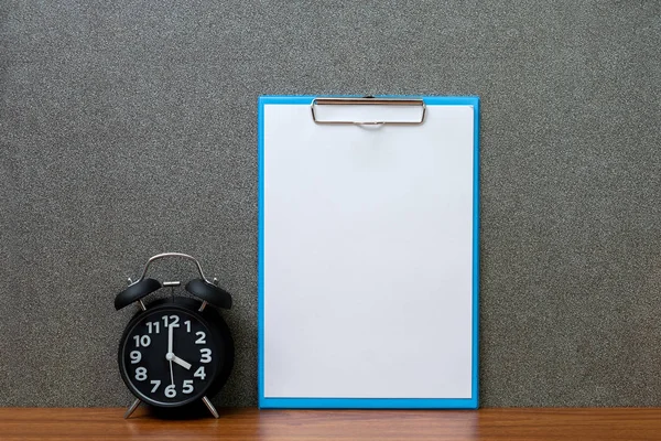 Reloj despertador vintage negro con portapapeles y papel blanco en blanco , — Foto de Stock