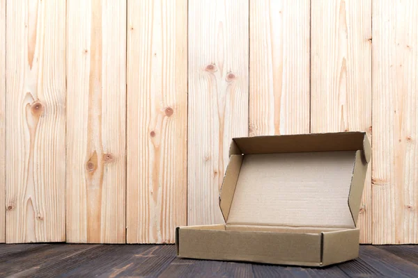 Pacote vazio caixa de papelão marrom ou bandeja em fundo de madeira , — Fotografia de Stock