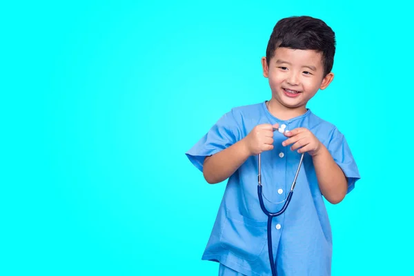 Sonriente niño asiático en uniforme médico azul celebración estetoscopio lo —  Fotos de Stock